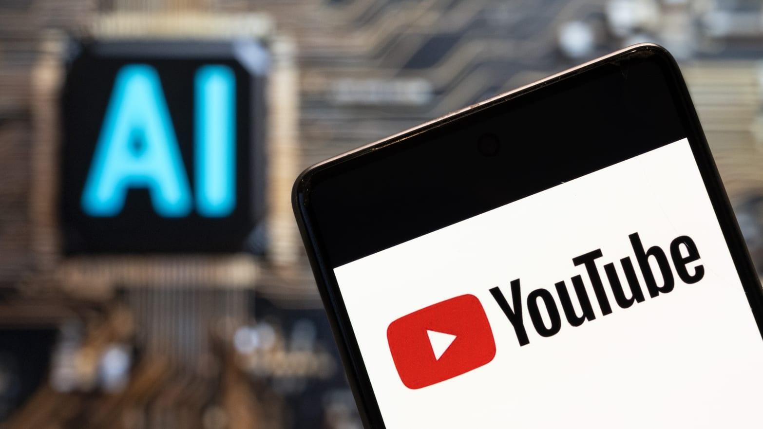 In this photo illustration, the American video-sharing website platform owned by Google, YouTube, logo seen displayed on a smartphone with an Artificial intelligence (AI) chip and symbol in the background. 