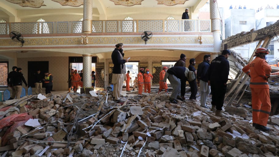 Locals and rescue workers stand amid the rubble, after a suicide blast in a mosque in Peshawar, Pakistan, Jan. 31, 2023.