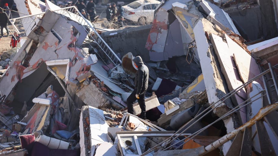 A man stands amid the rubble at the site of a collapsed building, in the aftermath of the deadly earthquake, in Kahramanmaras, Turkey, Feb. 8, 2023.