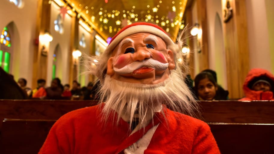 A Christian devotee dressed in Santa Claus costume attends prayers inside the Holy Family Catholic Church during Christmas celebrations in Srinagar.