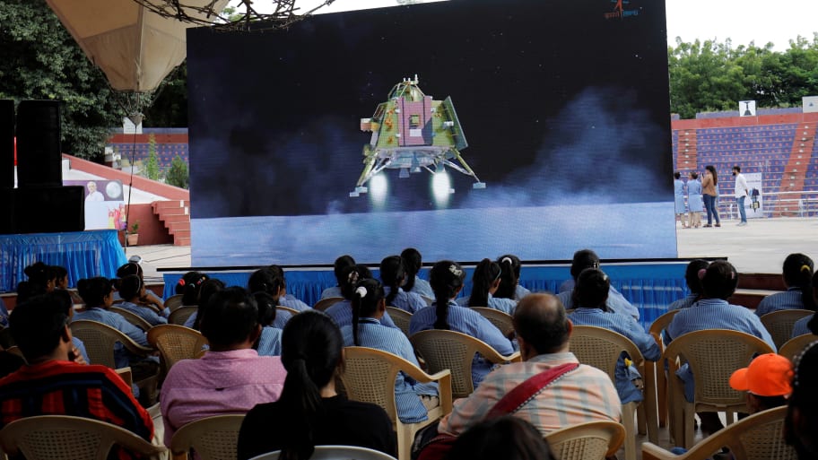 People watch a live stream of Chandrayaan-3 spacecraft’s landing on the moon, inside an auditorium of Gujarat Science City in Ahmedabad, India, Aug. 23, 2023. 