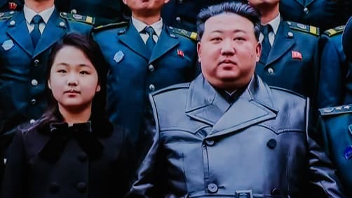 North Korean leader Kim Jong Un, center, and his daughter Kim Ju Ae pose for a photo with scientists and engineers who contributed to the country's latest launch of a reconnaissance satellite.