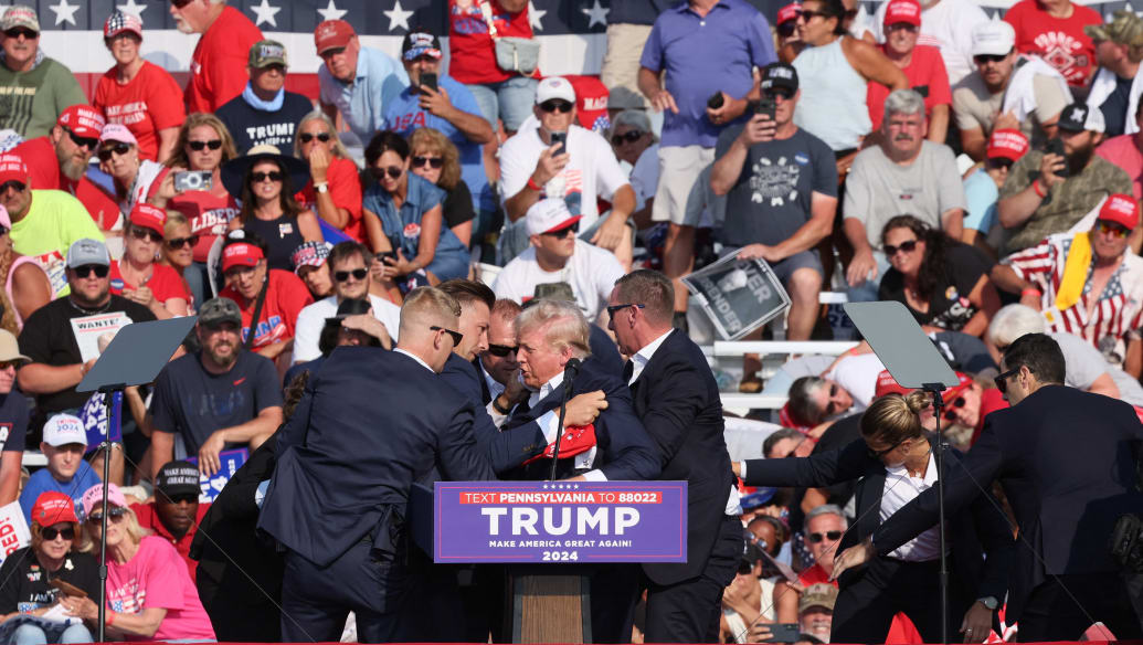 Donald Trump is swarmed by Secret Service agents on stage after he was shot at.