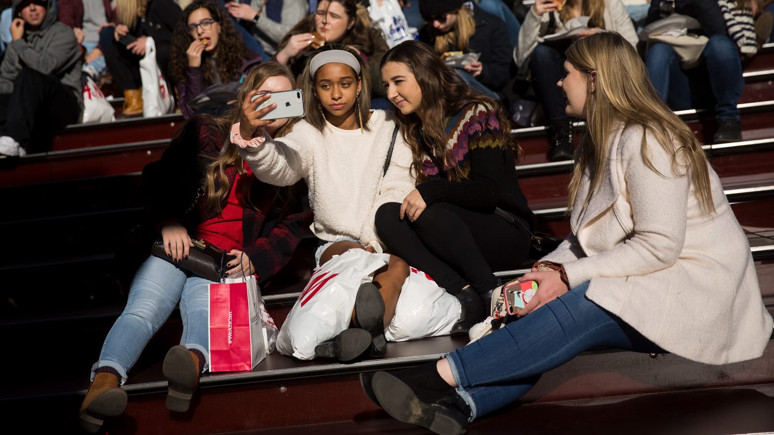 A group of teens take a photograph with a smartphone in Times Square, December 1, 2017 in New York City