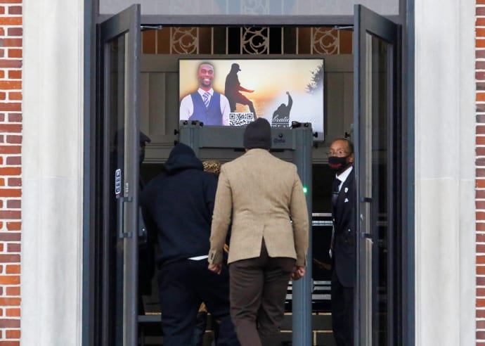 Photos of Tyre Nichols displayed on a screen as mourners enter his funeral. 