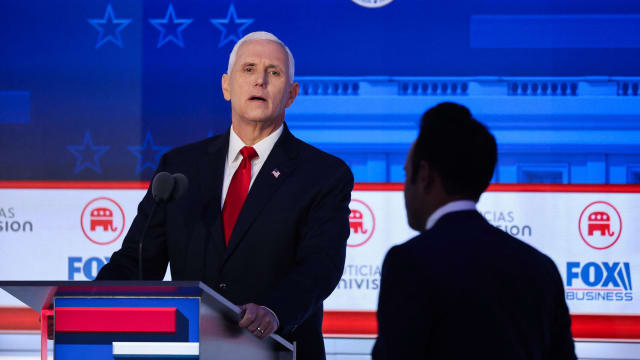 Former U.S. Vice President Mike Pence looks past former biotech executive and fellow Republican presidential candidate Vivek Ramaswamy during a break