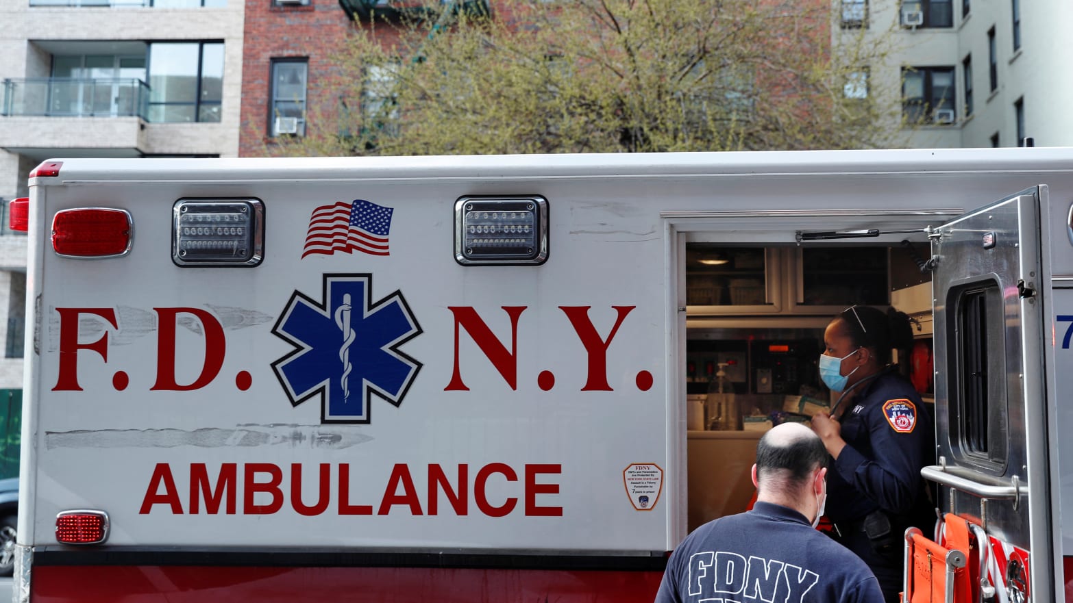 A FDNY ambulance sits with a door open.