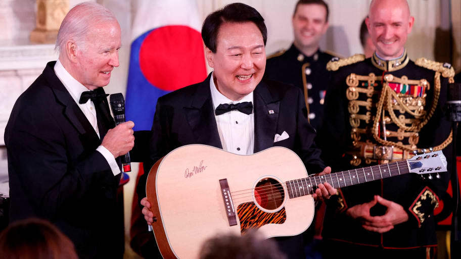 U.S. President Joe Biden presents a guitar signed by artist Don McLean during South Korea's President Yoon Suk Yeol's visit at the White House in Washington, U.S. April 26, 2023. 