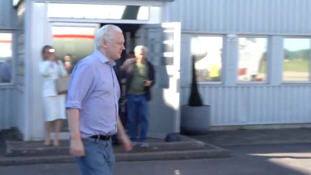 WikiLeaks founder Julian Assange walks to board a plane at a location given as London, Britain, in this still image from video released June 25, 2024. 