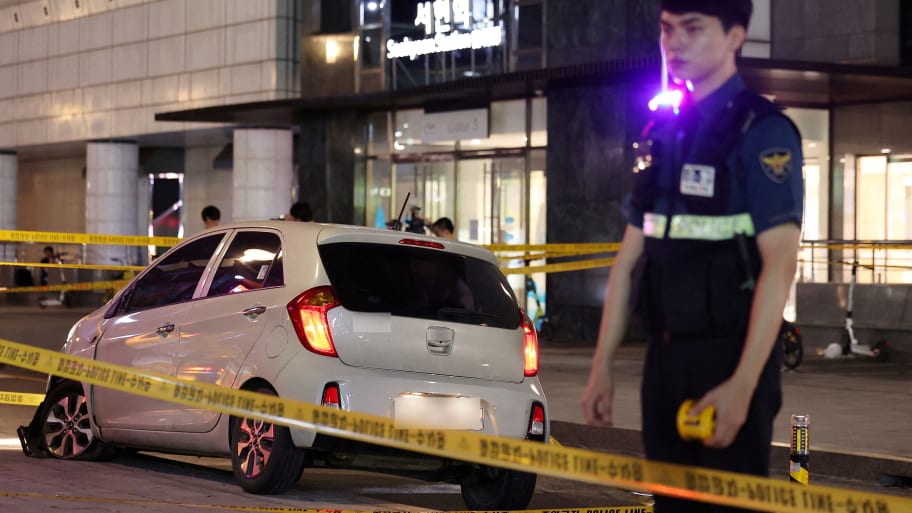 A policeman stands next to a scene where, according to media reports, nine people have been stabbed and four others hurt by a car driven by the suspected attacker in Seongnam, South Korea, Aug. 3, 2023.