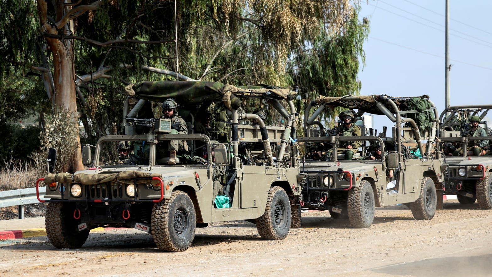 Israeli soldiers drive in military vehicles by Israel's border with Gaza in southern Israel, October 10, 2023.