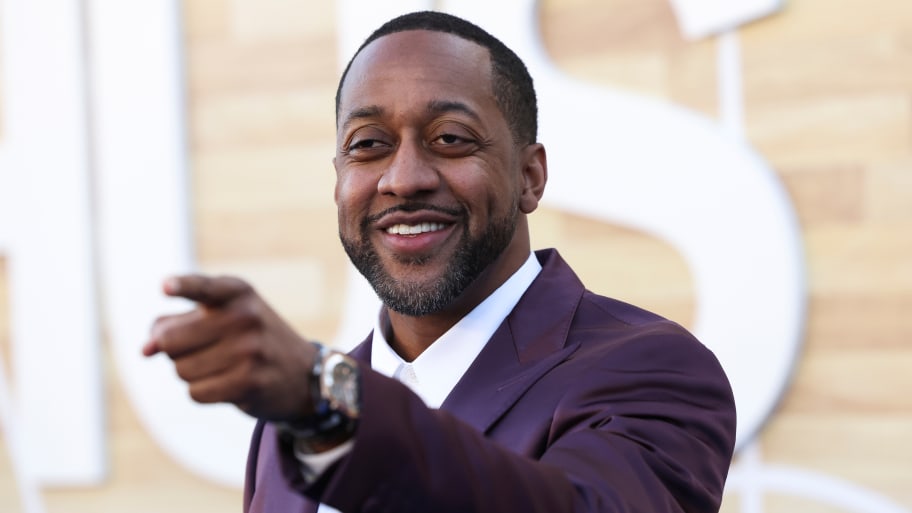 Jaleel White smiles and points outside a movie premiere.