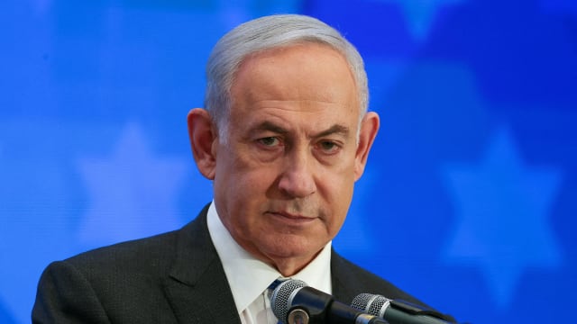Israeli Prime Minister Benjamin Netanyahu before a blue background.