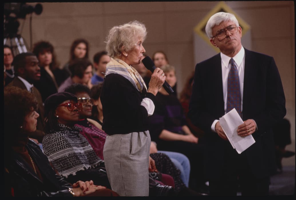 Phil Donahue with a member of the audience who is speaking