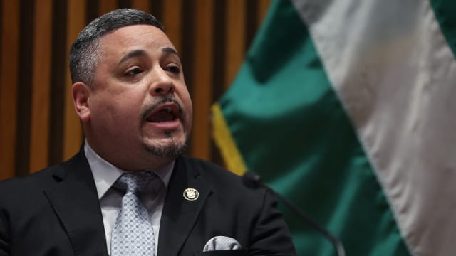 Edward Caban speaks while seated during a press conference.