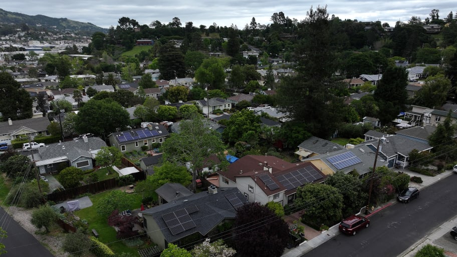 In an aerial view, solar panels are seen on the roofs of homes in a neighborhood on April 25, 2024 in San Rafael, California. 