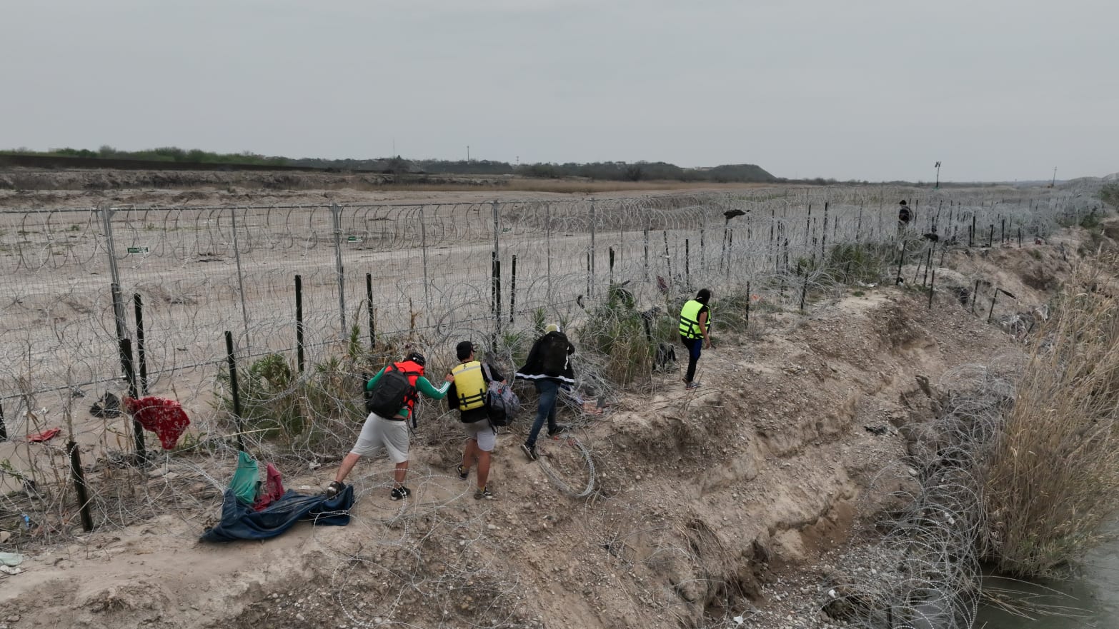 A group of irregular migrants' illegal crossings continue climbing up wire fences with their belongings in Eagle Pass, Texas, Mexico, on February 28, 2024.