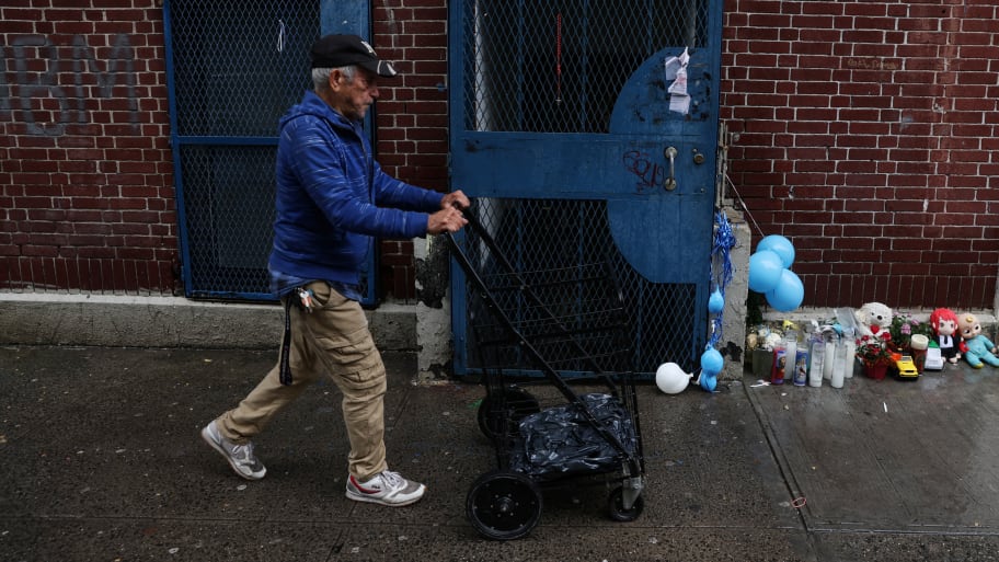 A man pushes a cart by a makeshift memorial for one-year-old Nicholas Dominici, who died after being exposed to fentanyl.