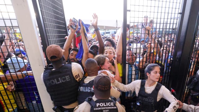 Fans crushed against a gate which is being held open by police