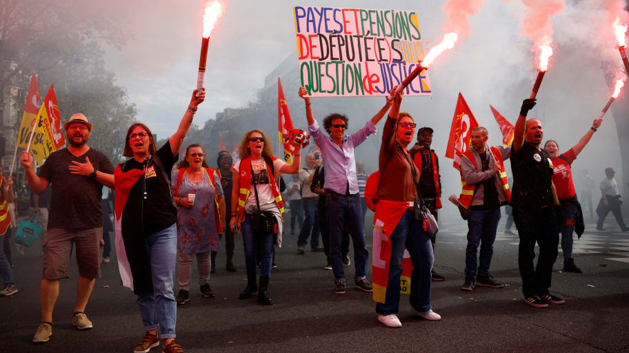 Members of the French CGT labor union hold red flares.