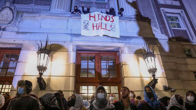 Protesters link arms outside Hamilton Hall barricading students inside the building at Columbia University in New York.