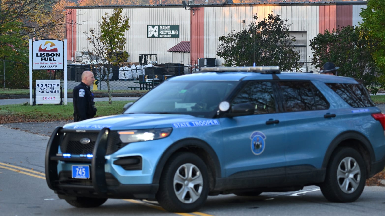 Police stand near the recycling plant where the body of suspected mass shooter Robert Card was found in Lisbon Falls, Maine.  