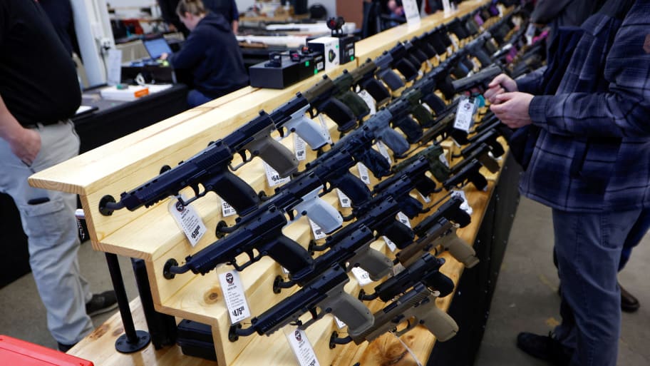 Customers shop for handguns at the Des Moines Fairgrounds Gun Show at the Iowa State Fairgrounds in Des Moines, Iowa