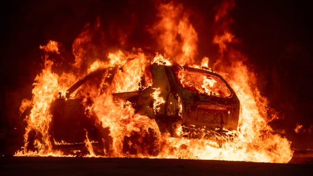 A car explodes into flames as the Camp wildfire tears through downtown Paradise, California.