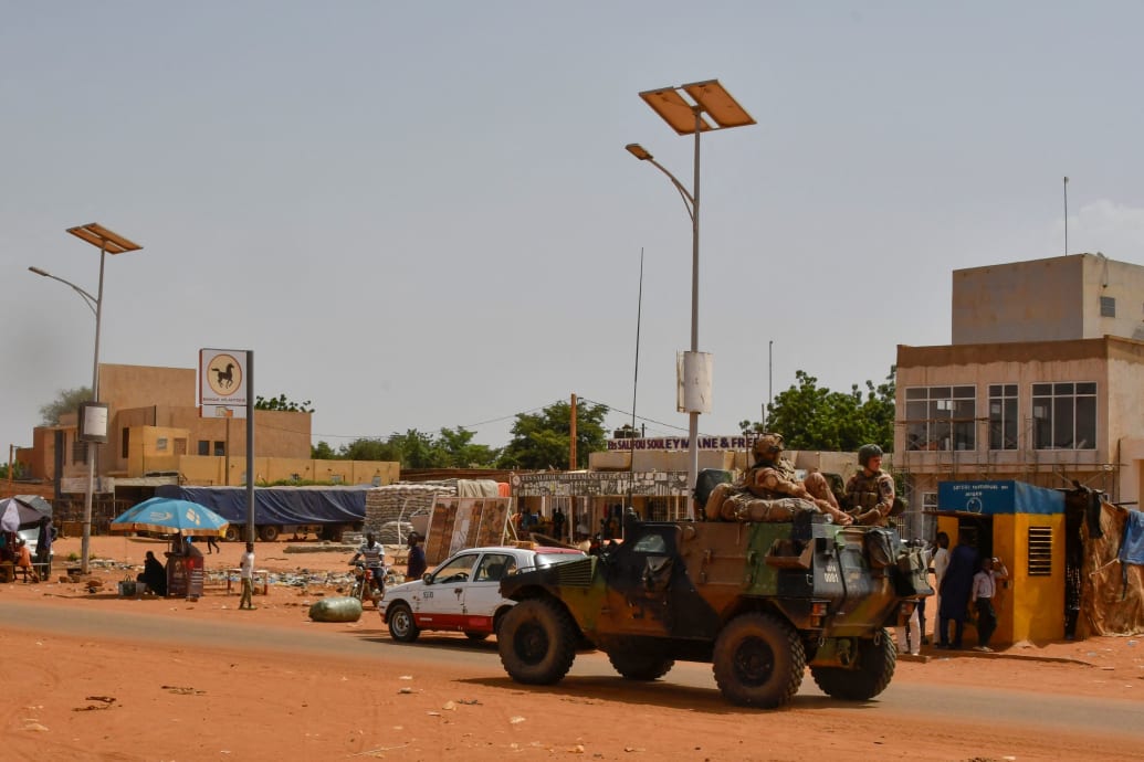 A picture of an armored vehicle rolling through the streets of Niger.