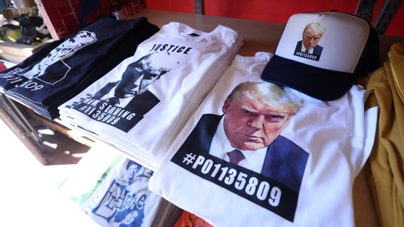 T-shirts and hats with an image depicting the mugshot of former U.S. President Donald Trump are pictured after being printed at the Y-Que printing store in Los Angeles