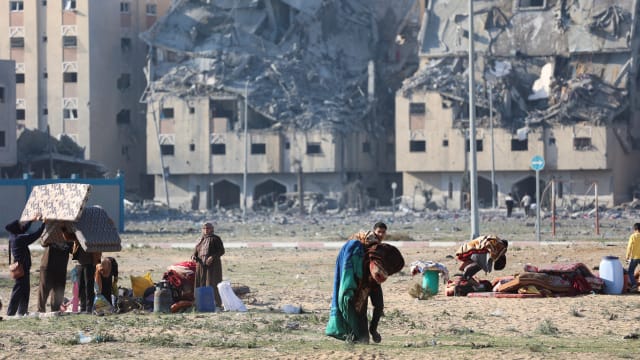 Palestinians carry their belongings following Israeli strikes in Khan Younis in the southern Gaza Strip.