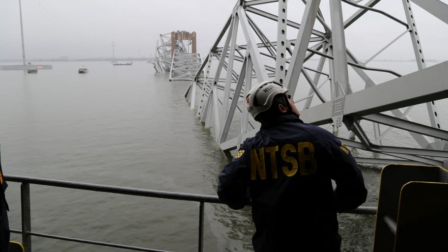 A National Transportation Safety Board (NTSB) worker looks on at the cargo vessel Dali, which struck and collapsed the Francis Scott Key Bridge in Baltimore.