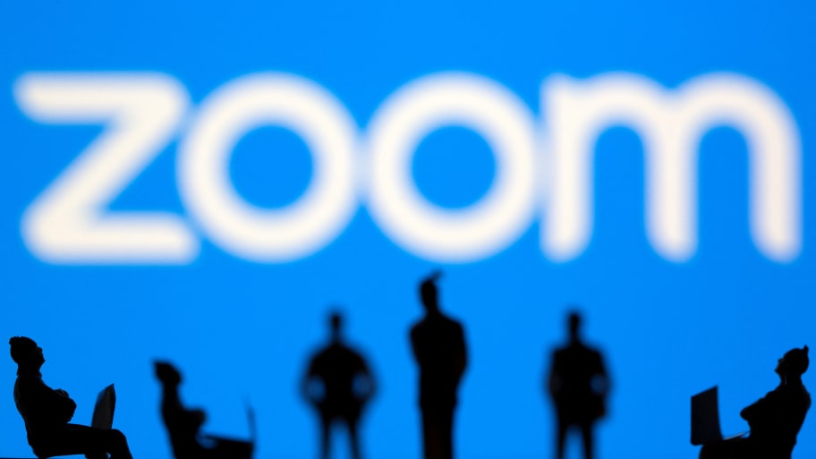 Small toy figures are seen in front of Zoom logo in this illustration picture taken March 15, 2021