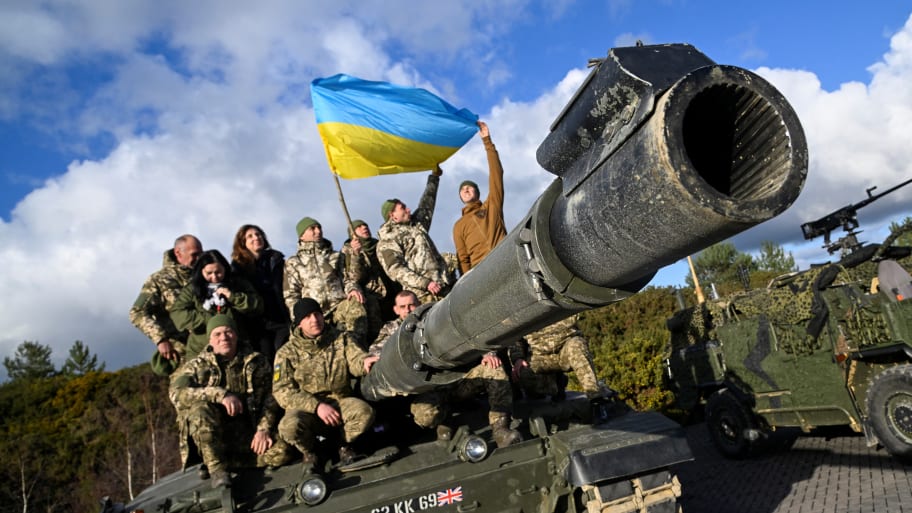 Ukrainian personnel pose with a flag on top of a Challenger 2 tank during a training at Bovington Camp, near Wool in southwestern Britain, Feb. 22, 2023. 