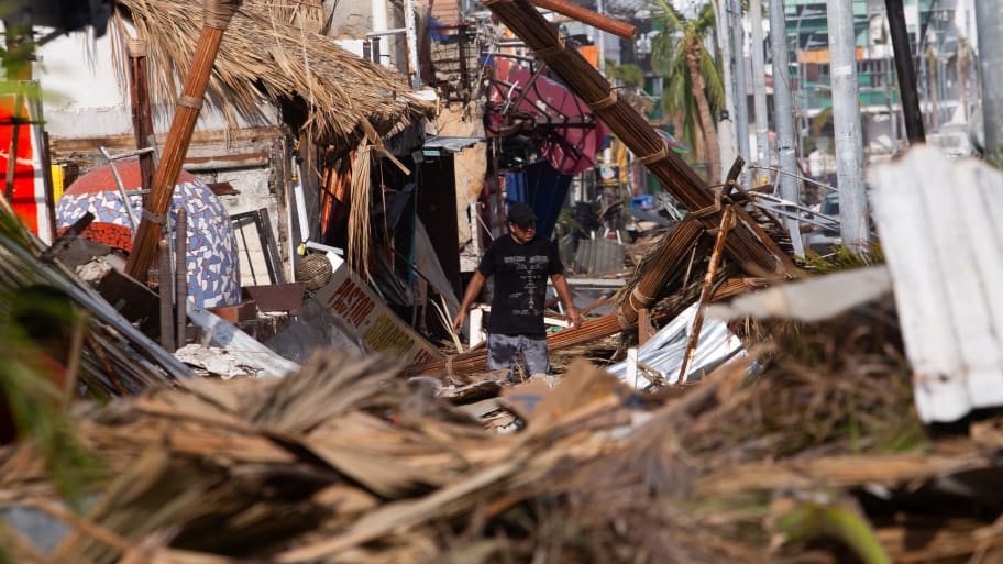 A man walks among rubble, in the aftermath of Hurricane Otis, in Acapulco.