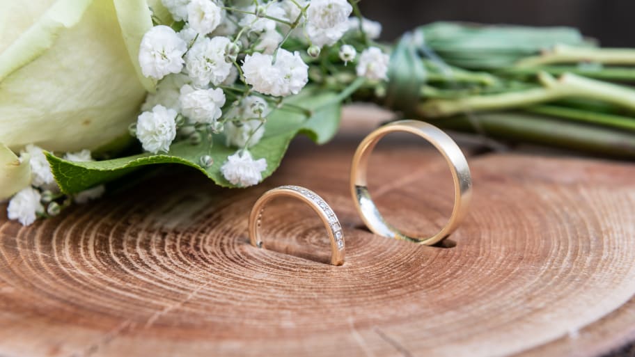 Wedding rings are draped on a piece of wood before a free wedding ceremony begins.
