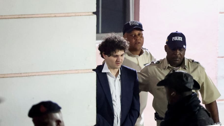 Sam Bankman-Fried is escorted out of the Magistrate Court building after his arrest, in Nassau, Bahamas December 13, 2022.