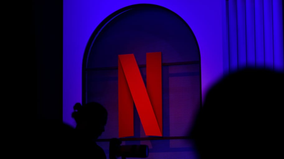 A man is standing with a camera near Netflix's N logo at an event in Mumbai, India, on February 29, 2024.
