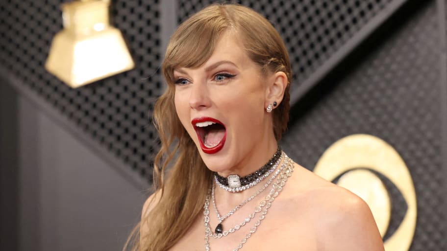 Taylor Swift reacts in excitement with her mouth open outside an award show.