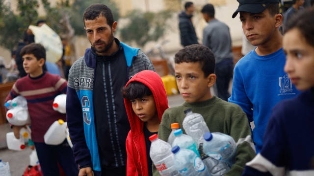 Palestinian children queue to collect water amid water shortages during the ongoing conflict between Israel and Palestinian Islamist group Hamas, in Rafah in the southern Gaza Strip.