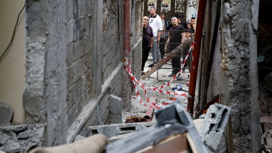 Palestinians inspect a house damaged during an Israeli raid, in Balata camp, Nablus, West Bank, May 22, 2023.
