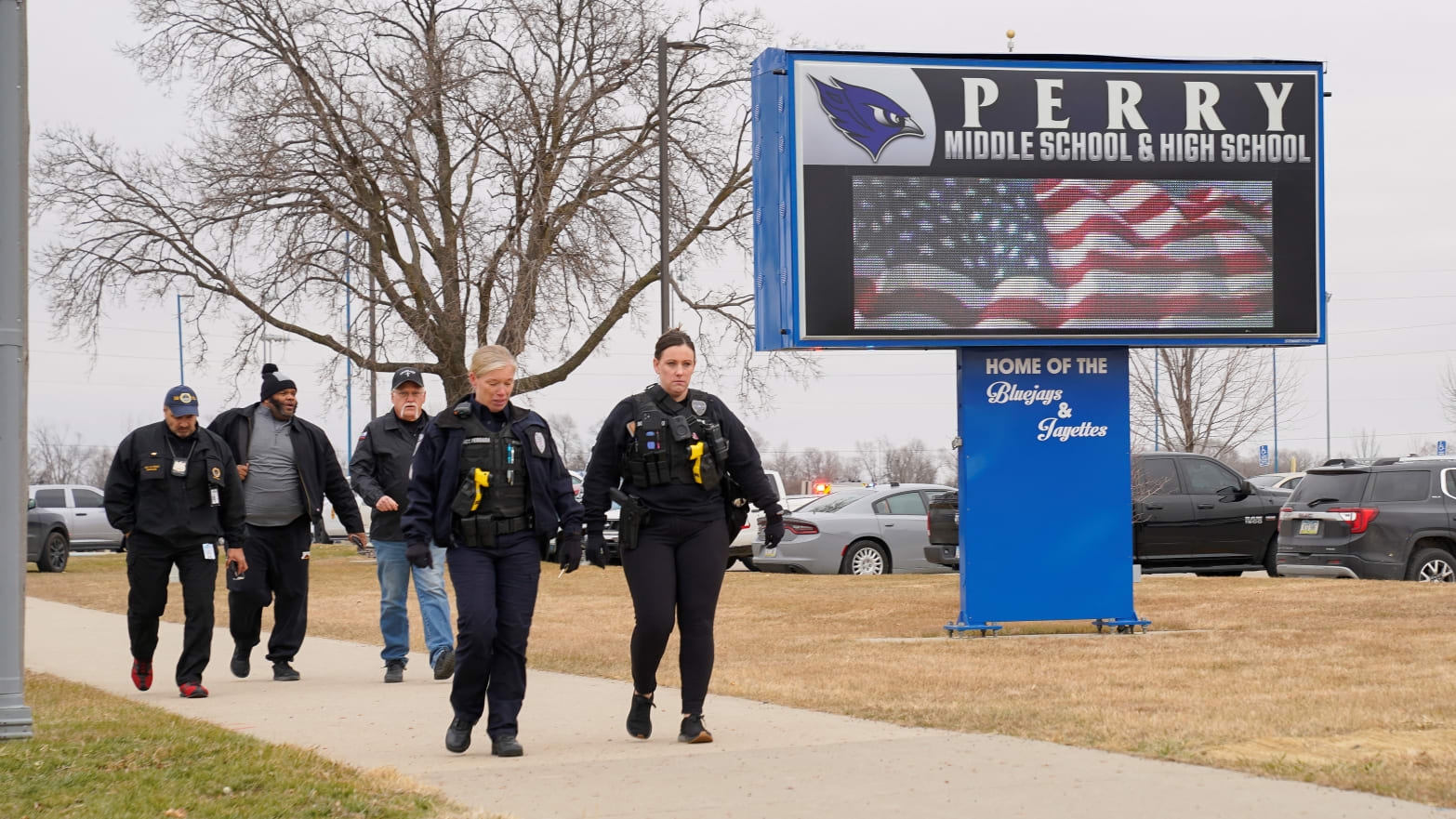 Officers walk outside of Perry High School in Iowa.
