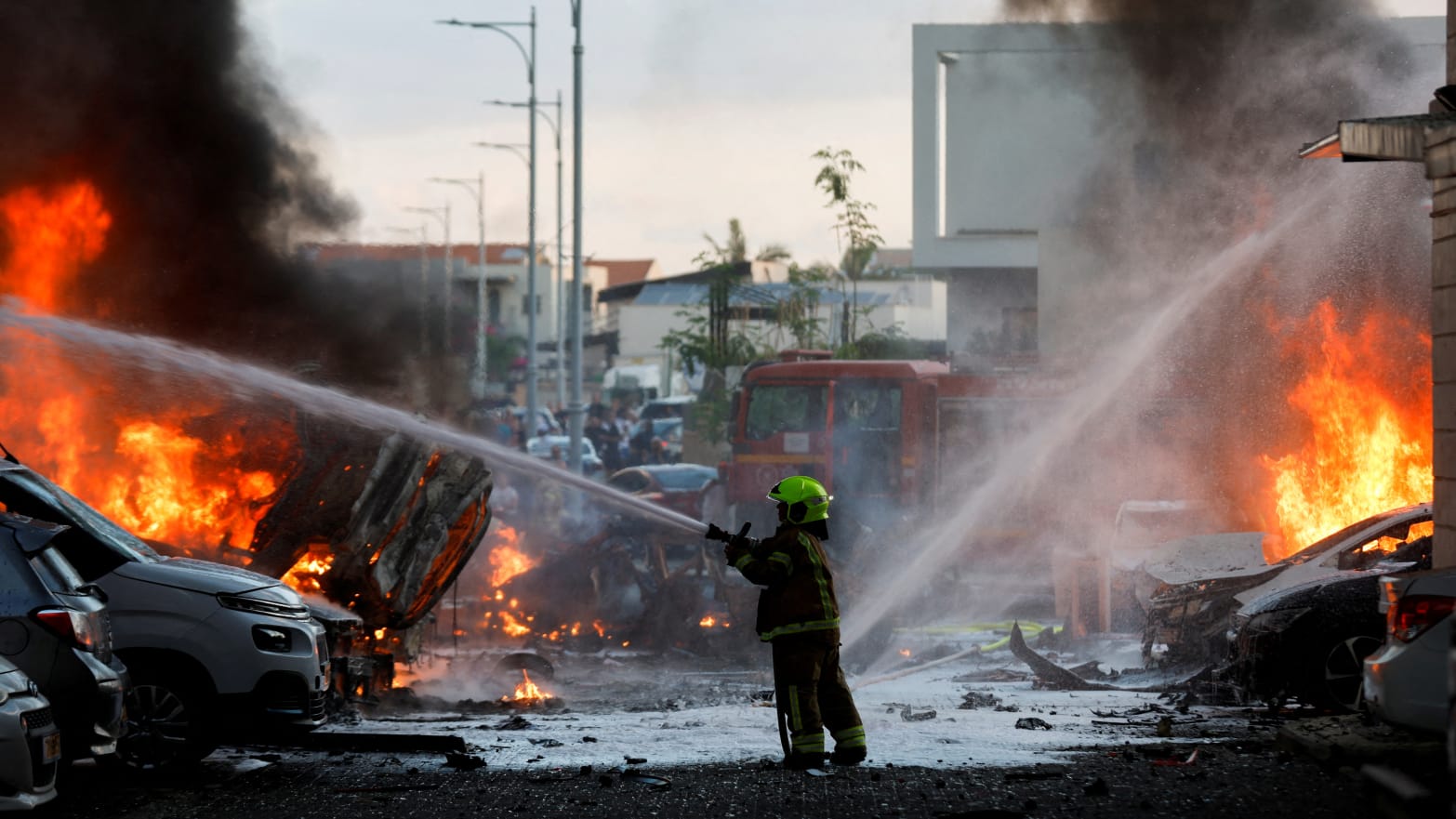 An emergency personnel works to extinguish the fire after rockets are launched from the Gaza Strip, as seen from the city of Ashkelon, Israel