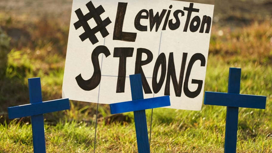 A memorial of blue crosses and a poster reading “Lewiston Strong.”