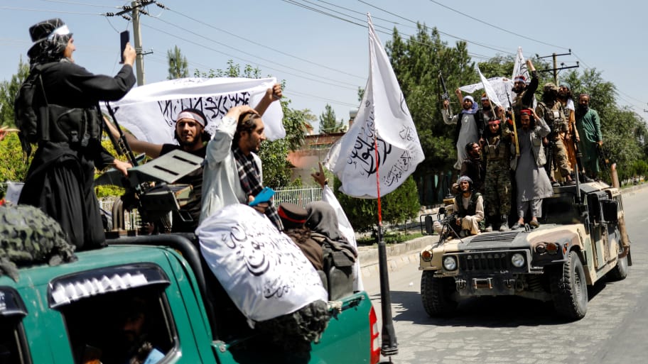 Members of the Taliban ride atop a military vehicle on the first anniversary of the withdrawal of U.S. troops from Afghanistan, on a street in Kabul, Afghanistan, August 31, 2022. 