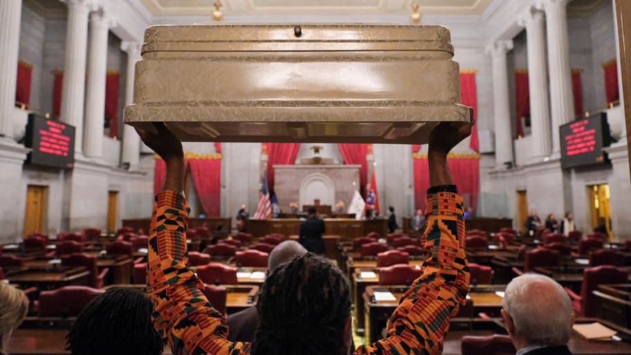 A protester holds an empty children’s casket while waiting for Tennessee House of Representatives Speaker Cameron Sexton in Nashville, Tennessee, April 17, 2023.