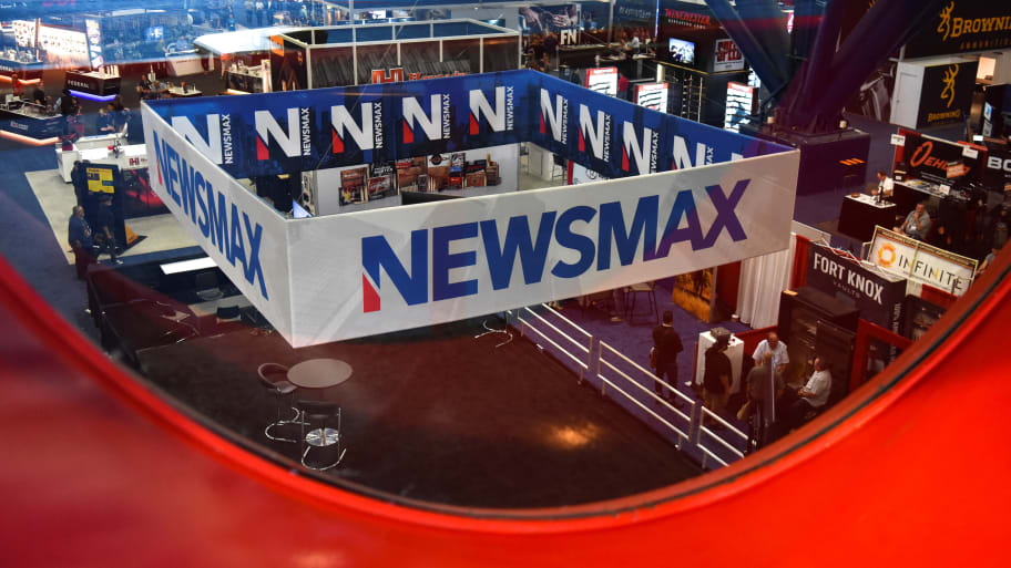 A Newsmax booth sits in the middle of a conference floor.