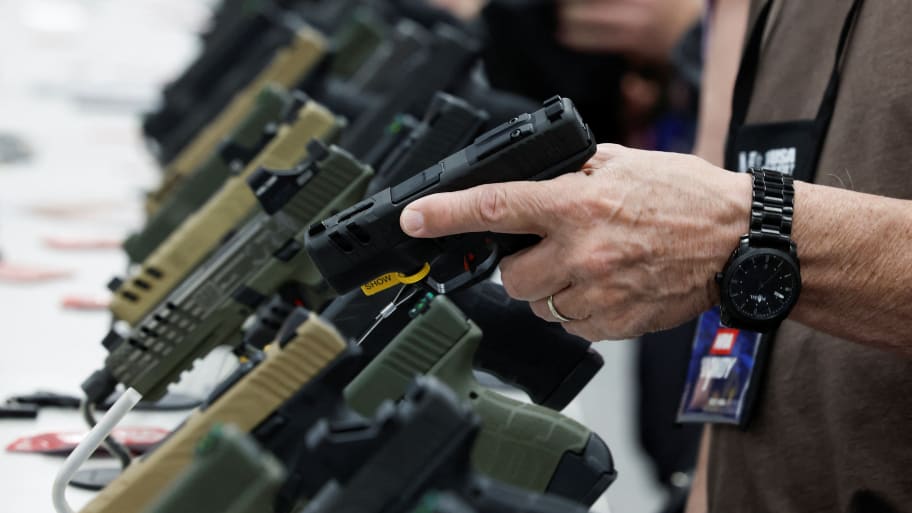A person tries out a handgun during the National Rifle Association (NRA) annual convention in Indianapolis, Indiana, U.S., April 15, 2023.