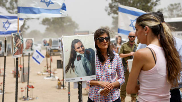 Nikki Haley speaks with survivors of the Oct. 7 attack with Israeli flags waving in background.