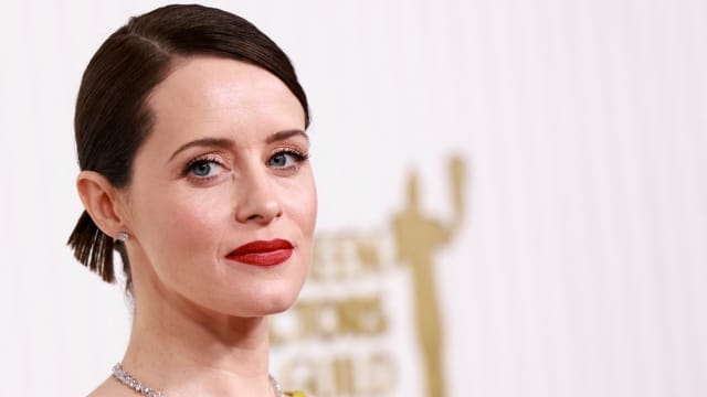 Claire Foy, wearing a yellow dress, poses at the Screen Actors Guild Awards in February.